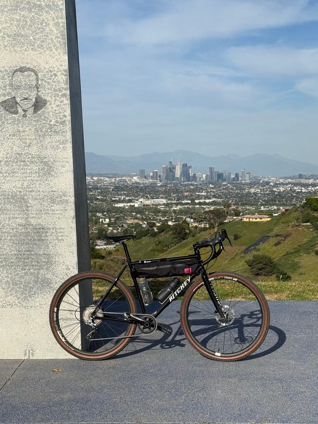 A black Ritchey Swiss Cross gravel bike at an overlook, downtown Los Angeles and the mountains behind